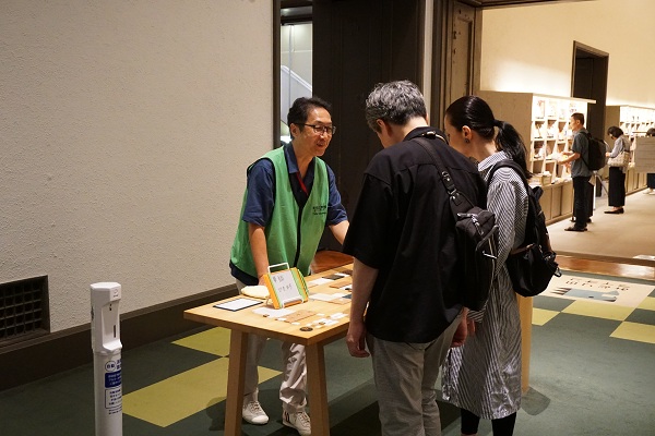 本館19室の触知図で博物館内を説明するボランティアのイメージ画像