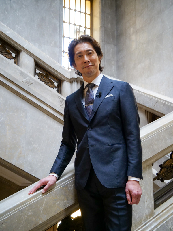 本館大階段に立つ佐々木蔵之介さん