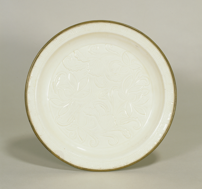 Image of "White porcelain dish with lotus flower design."