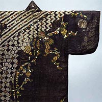 Image of "Kosode (Garment with Small Wrist Openings), Floral plants, cranes, turtles and geometrical patterns on reddish black figured satin (detail), Edo period, 16th century (Important Cultural Property)"