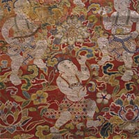 Image of "Textile Fragment, Gauze weave with embroidery; design of a floral arabesque and children on a red ground (detail), Ming dynasty, 14th–15th century"
